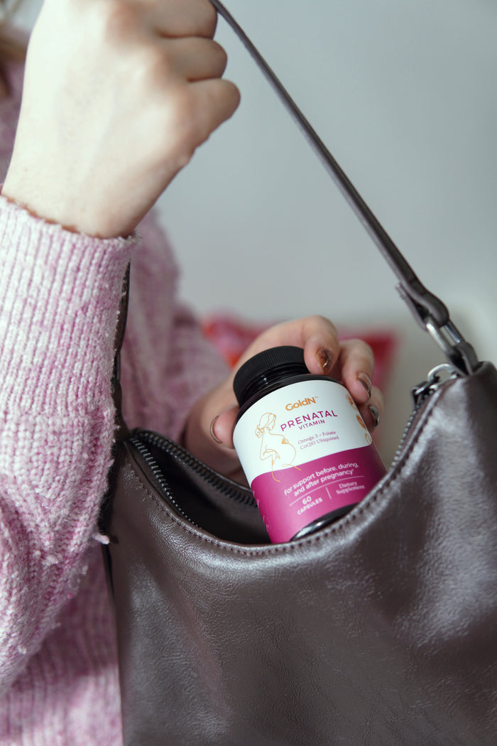 GoldN Prenatal with CoQ10 bottle being placed into a handbag