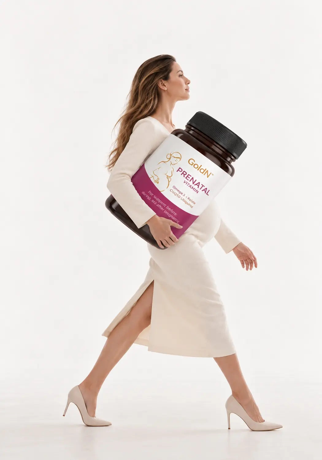 Woman walking in a cream dress carrying an oversized GoldN Prenatal Vitamin bottle