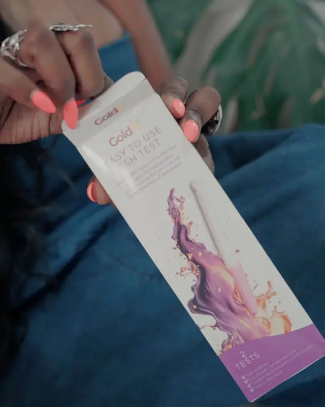 Woman holding the GoldN FSH Menopause Test box and test strip